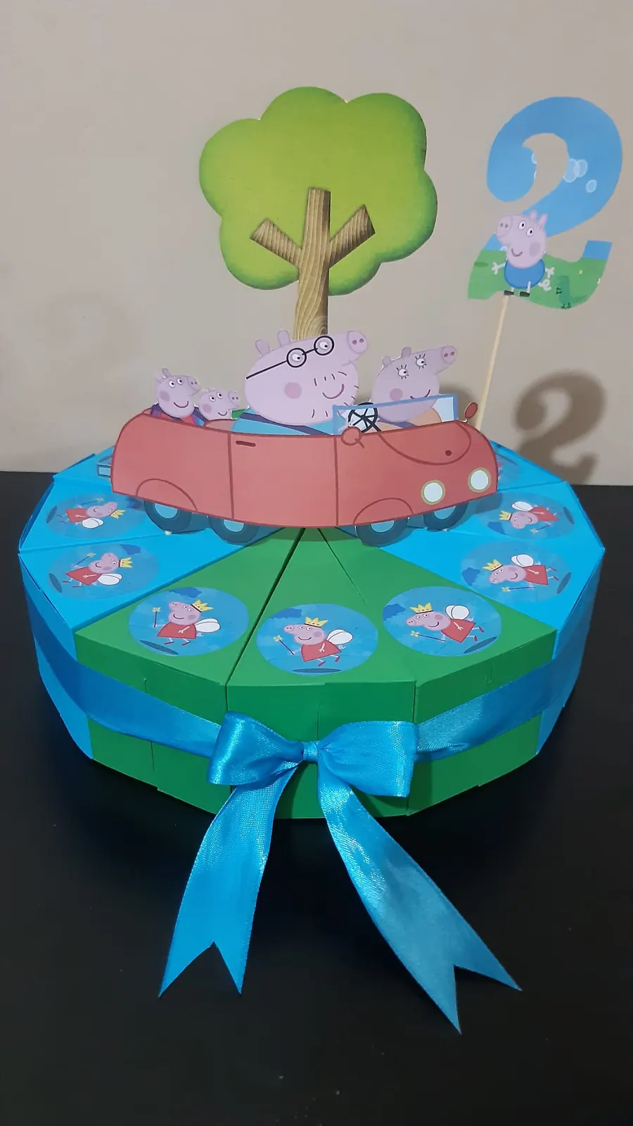 Plavo-zelena torta od kartona sa figurama životinja u autu i drvetom